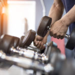 Person lifting dumbbell off of a rack